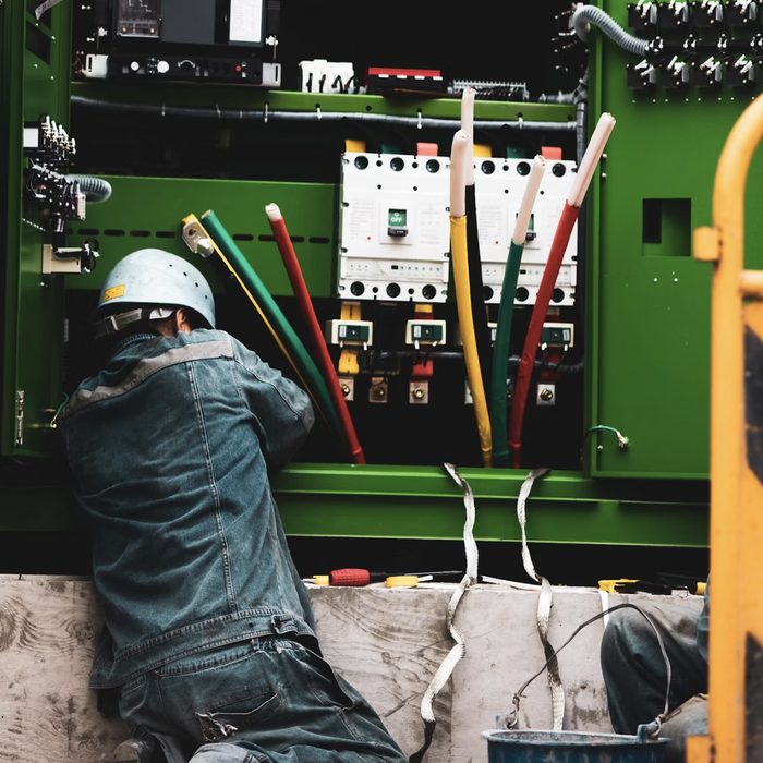 Teknisi mengerjakan panel switchgear listrik